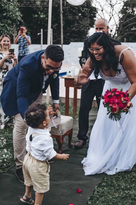 noivos recebendo seu pajem em casamento ao ar livre'