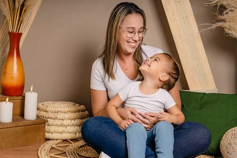 Especial de dia das mães, em estúdio, com cenário no estilo boho, em tons terrosos, feitas em Taquara com mãe e filha sorrindo olhando uma para a outra'