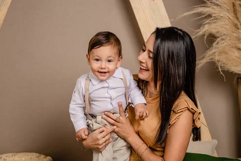 Especial de dia das mães, em estúdio, com cenário no estilo boho, em tons terrosos, feitas em Taquara com mãe e filho sorrindo'