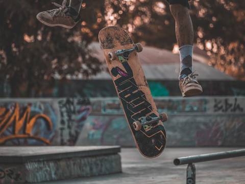 Skate flutuando enquanto skatista manda uma manobra'