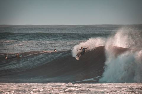 Homem surfando uma onda grande em kirra na australia'