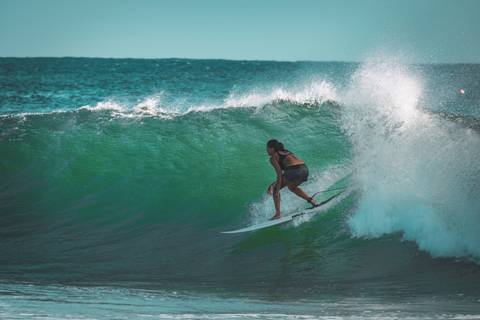 Mulher surfando em um tubo em praia na australia'
