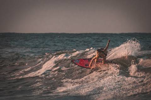 Mulher surfando fazendo um cutback em praia na australia'