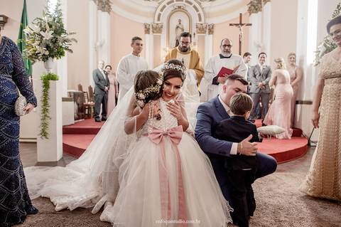 Fotografia espontânea dos noivos e pais acompanhando a entrada das alianças no casamento em Itu.'