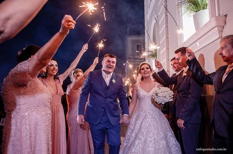 Saída triunfal dos noivos em Itu: convidados celebram com varetas de fogo na porta da Igreja do Quartel.'