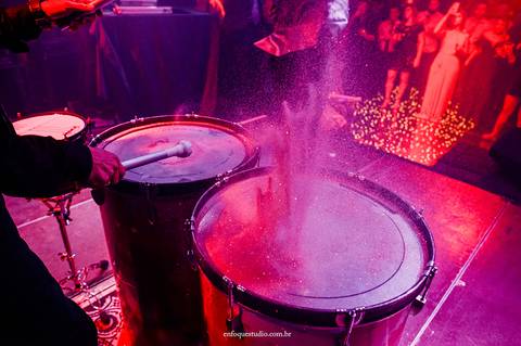 Detalhe artístico dos tambores iluminados soltando pó colorido na pista de dança da festa de casamento em Itu'