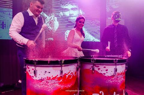 Noivos Gabriela e Guilherme tocando tambores iluminados no show interativo da festa de casamento no Hotel Plaza, em Itu'