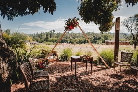 Cerimônia de casamento ao ar livre no Villa Itália em Piracicaba, com altar triangular decorado com flores naturais.'