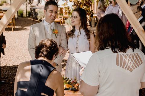 Durante a celebração, a noiva olha para o noivo com carinho, em um momento que reflete cumplicidade e conexão.'