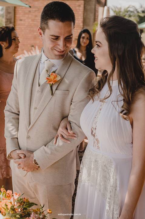 A noiva e o noivo trocam olhares apaixonados durante a cerimônia, evidenciando a verdade do momento.'