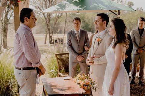 Com emoção e cumplicidade, o casal troca olhares enquanto o celebrante conduz a cerimônia.'