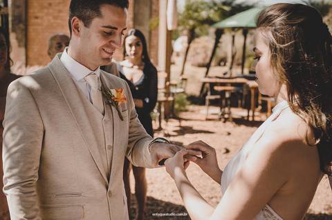 A noiva coloca a aliança no noivo em um instante cheio de significado durante a cerimônia ao ar livre em Piracicaba.'