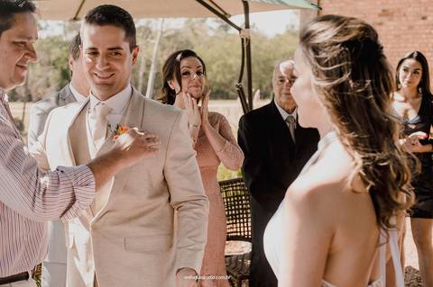 O noivo recebe a benção durante a cerimônia intimista realizada no Villa Itália, em Piracicaba e a mãe ao fundo segurando a emoção desse momento especial'