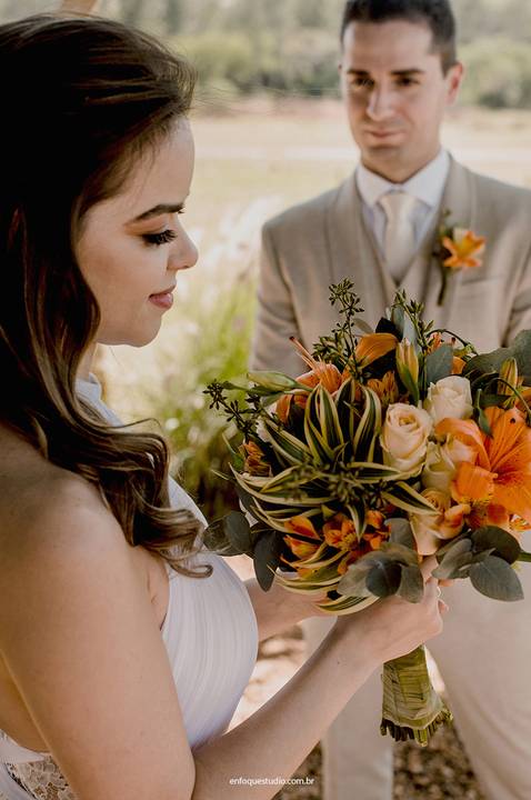 A noiva contempla seu buquê colorido durante o casamento intimista no Villa Itália, em Piracicaba.'