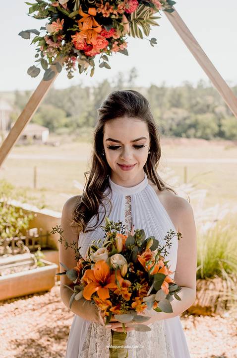 Registro da noiva com buquê em frente ao altar floral no Villa Itália, Piracicaba, em cerimônia leve e intimista.'
