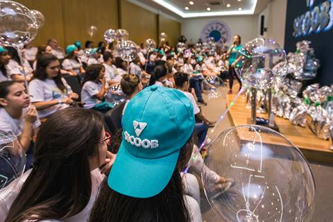 Foto publicitária de uma criança com boné do Banco Sicoob de Londrina-Pr.'