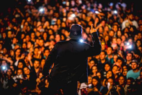 Apresentação da dupla Henrique e Juliano no recinto de show João Milanez, fotografia de show iluminada por luzes de smartphones.
'