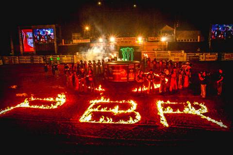 Cerimônia de abertura do rodeio na Expo Londrina, a fotografia valoriza os patrocinadores PBR e Monster Energy tendo ao fundo os peões de montaria.'