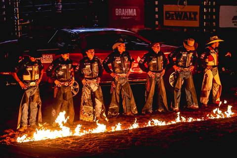 Peões de rodeio frente ao fogo em fotografia institucional de Roberto Custodio durante evento na Expo Londrina.'