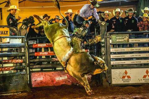 Imagem clássica do fotógrafo de eventos Roberto Custódio de um peão de rodeio em montaria de touro. '