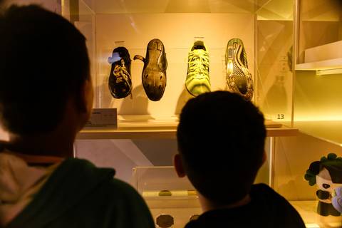 Crianças observam chuteiras da Seleção Brasileira de Futebol, objetivo do fotógrafo profissional em eventos foi propiciar uma imagem em que o público entenda o significado dos Jogos Olímpicos.'