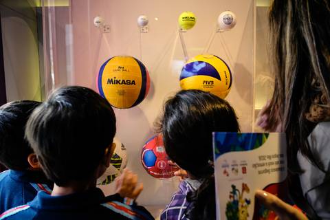 Estudante observam modelos de bolas de golf, futebol, voleibol, tênis e handebol em fotografia corporativa, as peças estão expostas no Museu Itinerante patrocinado por Bradesco Seguros.'