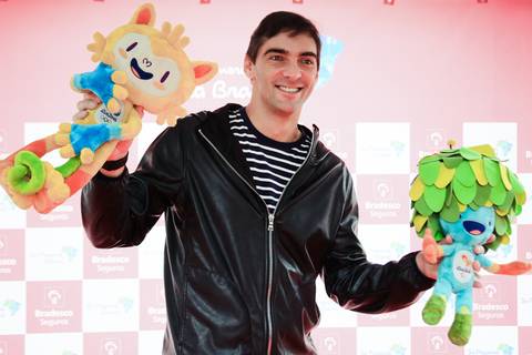 Fotografia institucional do embaixador-atleta do Bradesco Seguros Giba, segura os mascotes dos Jogos Olímpicos 2016, os nomes Vinicius e Tom homenageia astros da Bossa Nova.'