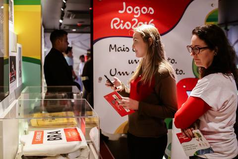 Fotografia corporativa de professoras tirando fotos de kimono de judô usado em alguma edição dos jogos olímpicos. '