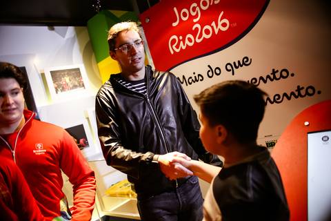Criança cumprimenta o jogador Giba em fotografia de eventos durante visita ao Museu Itinerante patrocinado pelo Bradesco Seguros.'