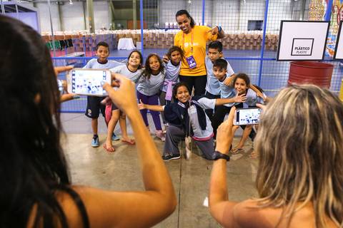 Fotografia esportiva de uma disputa de vôlei valorizando placa de publicidade da Coca Cola.'