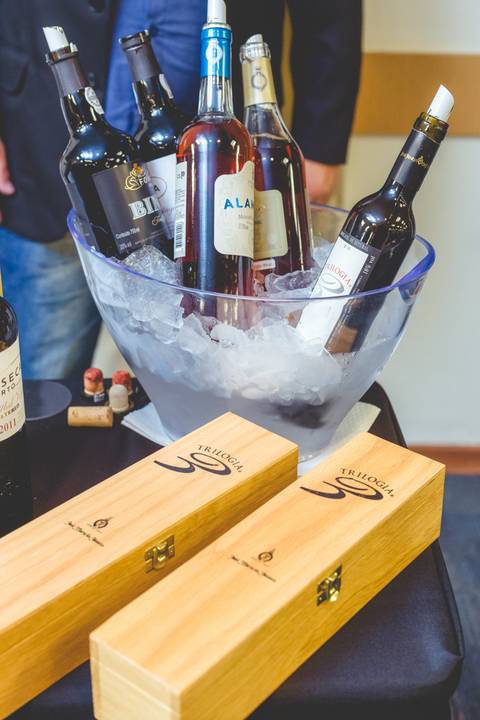 Fotógrafo profissional em Londrina detalha garrafas de vinho no gelo durante degustação.'