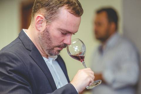 Fotógrafo em Londrina especialista em eventos mostra em foto exato momento de um enólogo cheirando uma taça de vinho.'