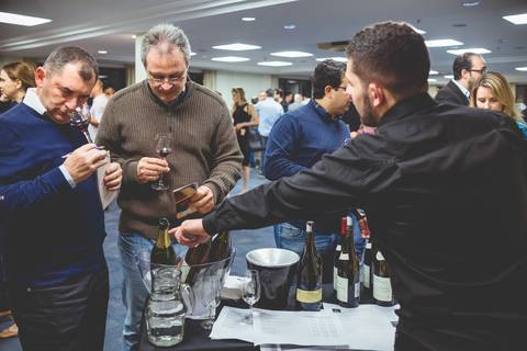 Jovem sommelier fala sobre vinhos a empresários de bares e restaurantes em imagem do fotógrafo de Londrina Roberto Custodio.'