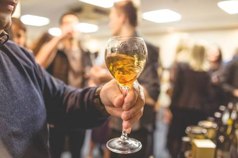 Taça de vinho branco sendo chacoalhada por enólogo para ser fotografado por fotógrafo de Londrina especializado em eventos corporativo.'