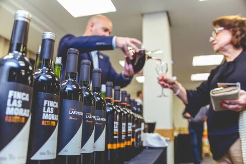 Fotógrafo profissional em Londrina registra um sommelier servindo uma senhora durante uma degustação de vinhos.'