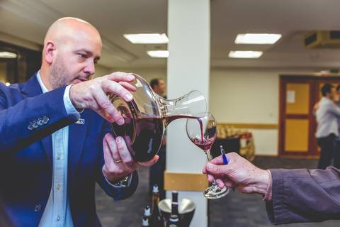 Detalhe de uma imagem feita por fotógrafo em Londrina de um Enólogo servindo vinho a um sommelier.'