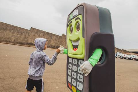Fotografia de evento corporativo de um menino brincando com boneco publicitário do Sicoob em Londrina-PR
'