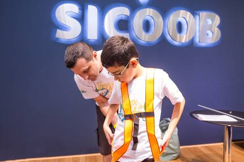 Menino sendo preso a cinto de segurança em fotografia corporativa por Roberto Custodio de Londrina-Pr.
'