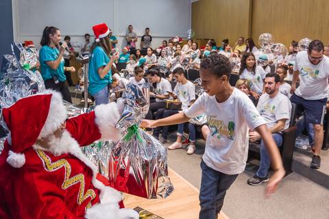 Menino pega presente do Papai Noel durante evento, o registro é de Roberto Custódio, fotógrafo de evento corporativo em Londrina-Pr.
'
