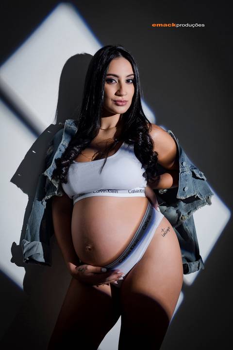 Ensaio gestante fine art com luz dramática'