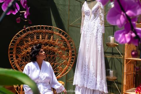 Noiva olhando para o seu vestido em ensaio making of para casamento em Guarapari'