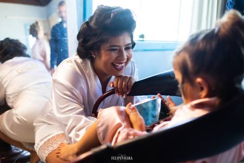 Noiva sorrindo com daminha de honra em seu ensaio making of em pré casamento'