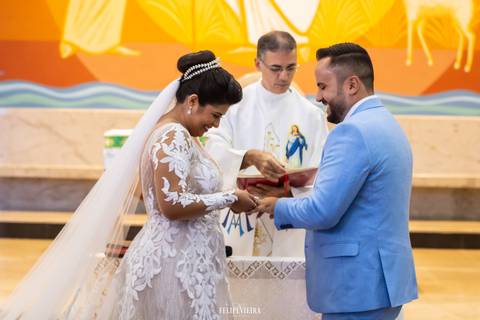 Noivos sorrindo e colocando alianças em casamento em Guarapari em igreja católica'