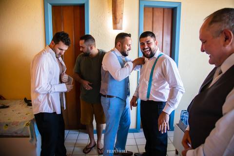 Padrinhos se arrumando e rindo em making of do noivo antes do casamento em meaípe em Guarapari'