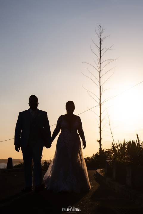 silhueta de noivos ao pôr do sol em foto de ensaio externo em 
casamento de guarapari '