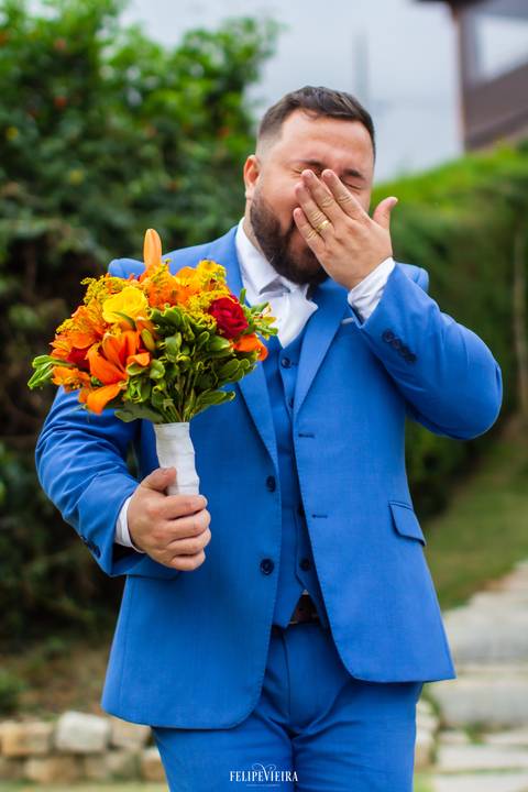 noivo brincando com o o buquê da noiva'