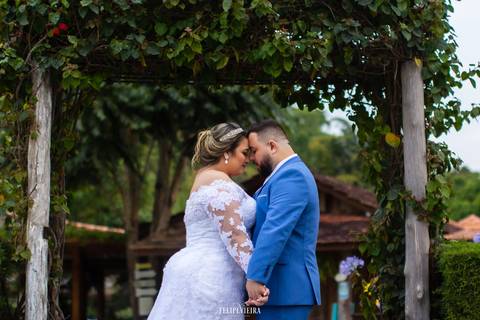Noivos em frente a um portal de arbustos durante ensaio pós wedding'