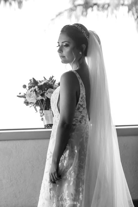 retrato da noiva com o vestido em renda e buquê nas mãos'