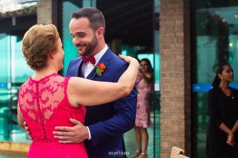 noivo com a mãe no altar com terno azul bic e lapela vermelha'