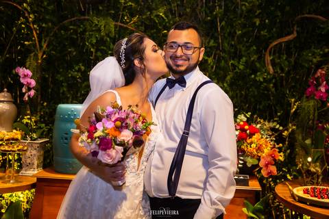 noiva com o buquê nas mãos beijando o irmão durante a festa de casamento'